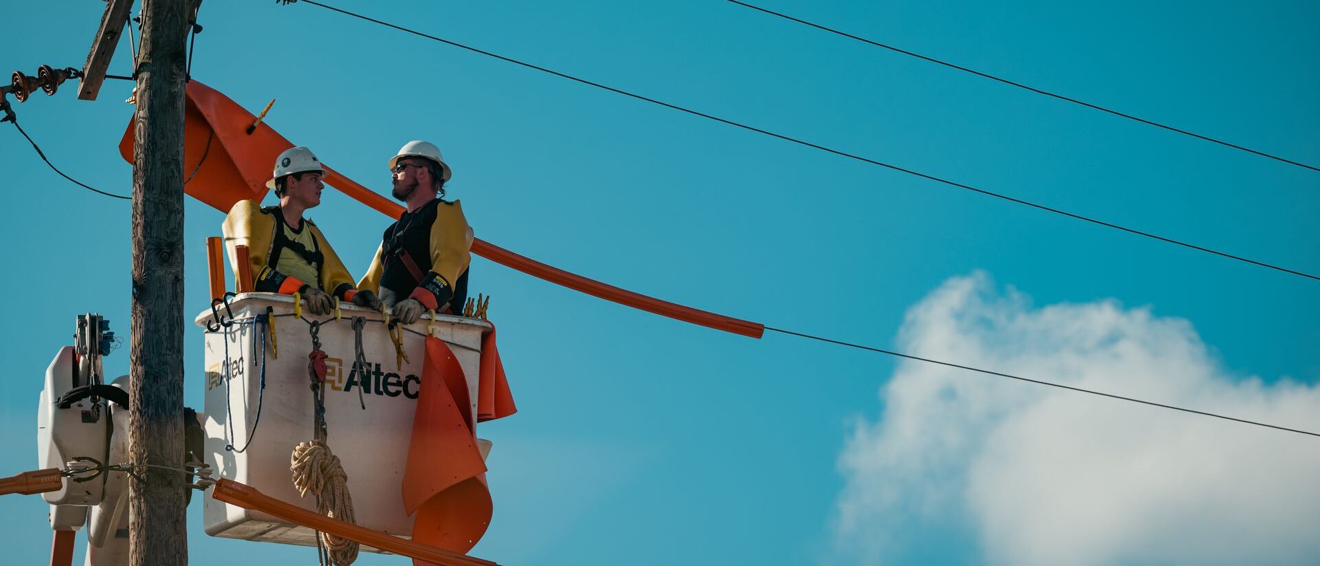 Linieros con equipo de protección trabajando en una red eléctrica