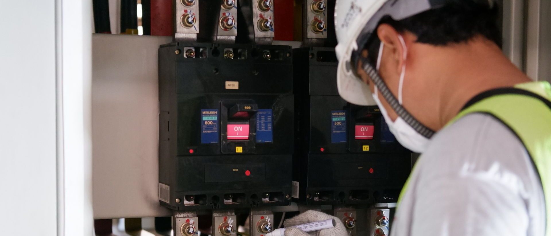 Técnico con equipo de protección revisando un tablero eléctrico industrial